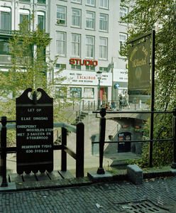 118615 Gezicht op enkele reclameborden aan de balustrade op de werfmuur langs de Oudegracht te Utrecht; op de ...